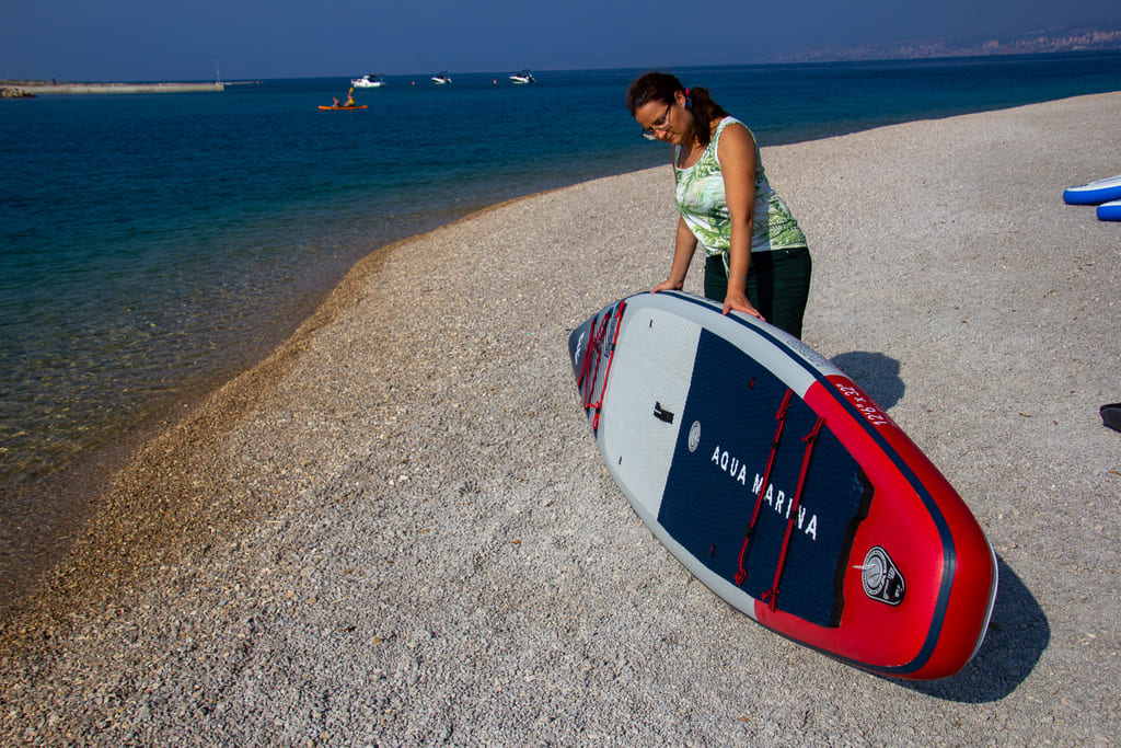 Dziewczyna trzyma na plaży deskę sup Hyper 2023
